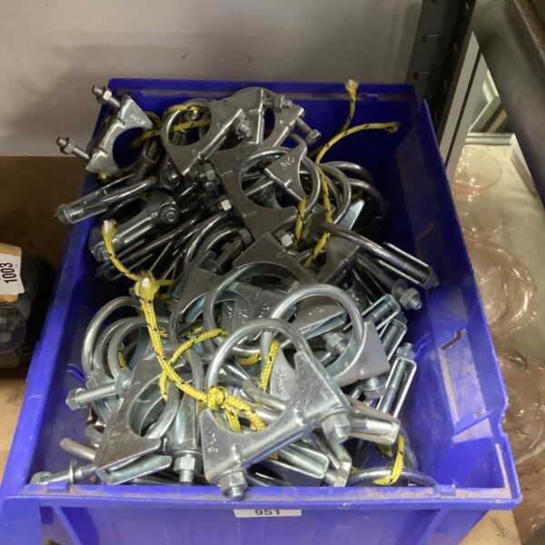 Box of used metal pipe clamps for plumbing and industrial applications.