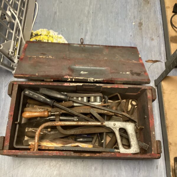 Open vintage wooden tool box filled with antique tools.