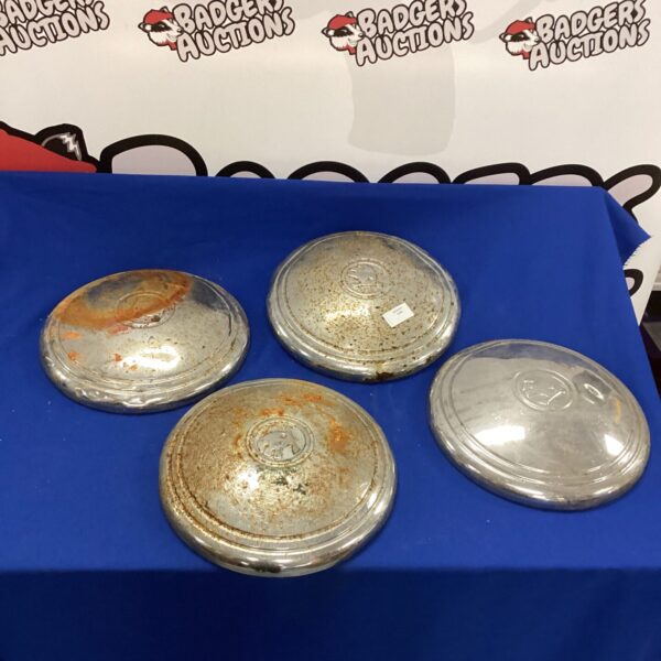 Vintage Skoda hub caps showing wear and the Skoda logo.