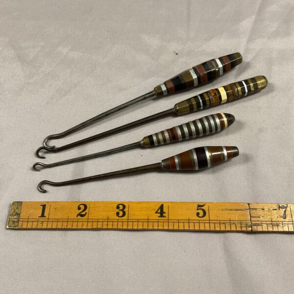 Set of four vintage trench art bootlace hooks.