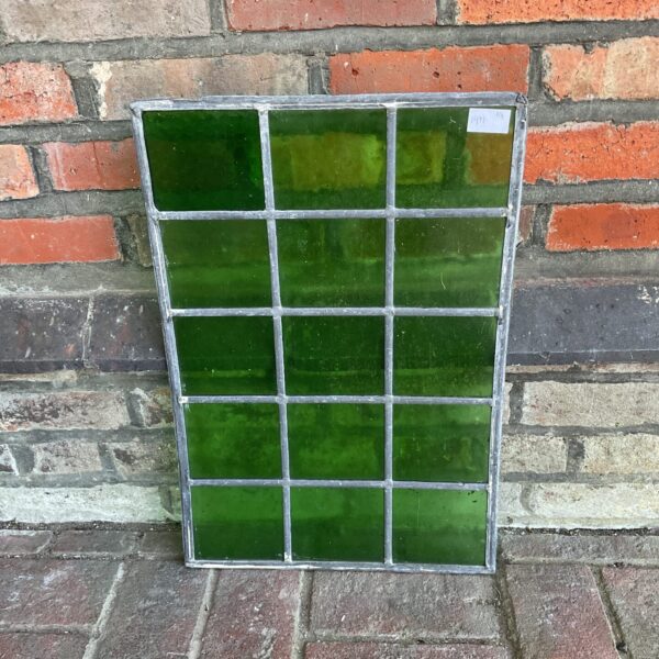 Vintage green stained glass window with geometric pattern.