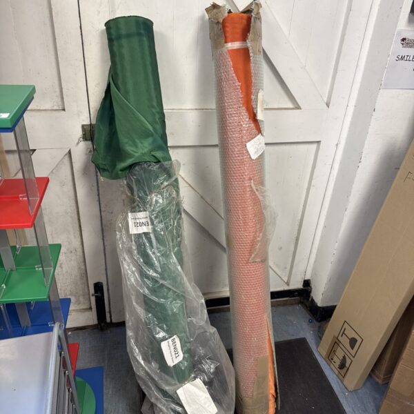 Large rolls of orange and green fabric for crafting projects.