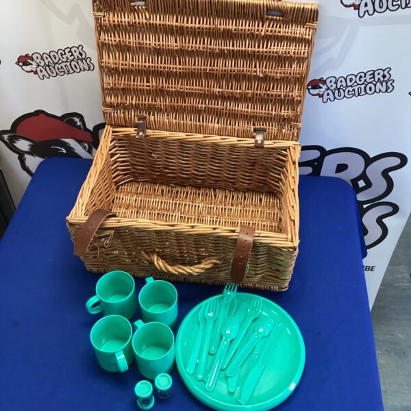 Vintage wicker picnic basket with colourful plastic picnic set.