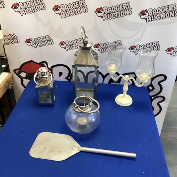 Vintage lantern collection with wooden pizza paddle displayed.