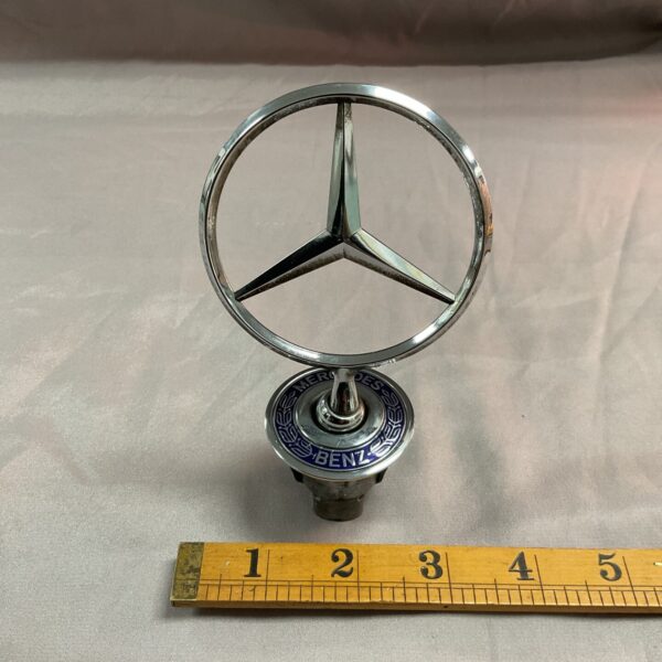 Vintage Mercedes Benz hood ornament with iconic star emblem.