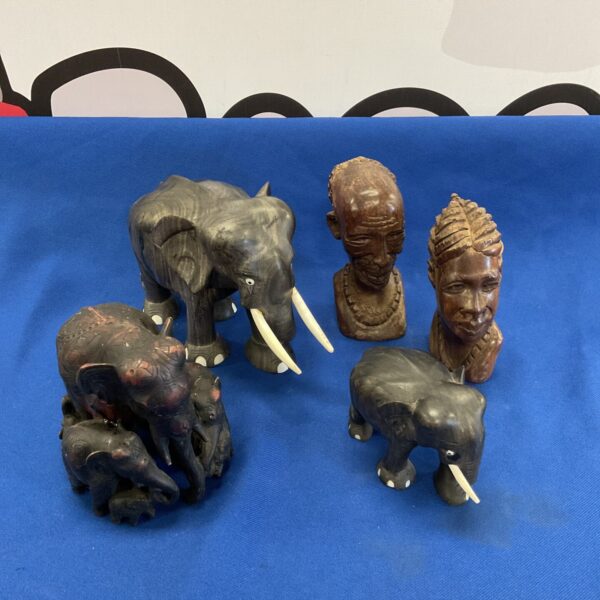 Vintage African carved wood figures, including busts and elephants.