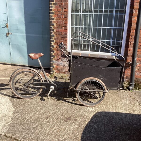 Vintage cargo bike with a large front box, ideal for deliveries.