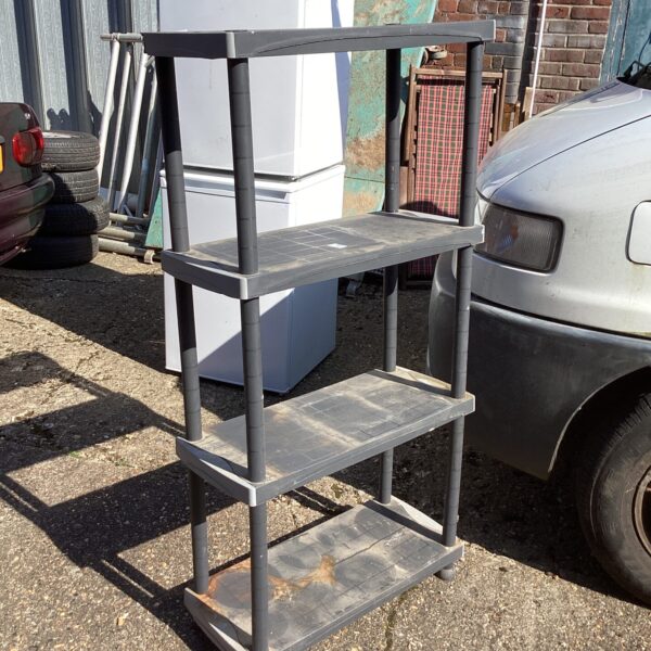 Four-tier plastic shelving unit for garage or utility storage.