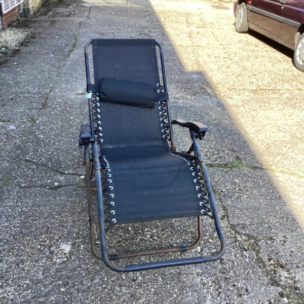 Folding sun lounger in a garden setting.