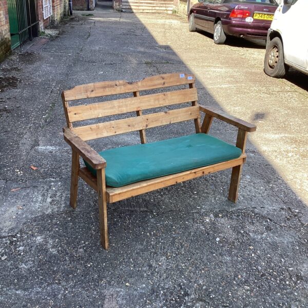 Weathered rustic garden bench with a slatted backrest.