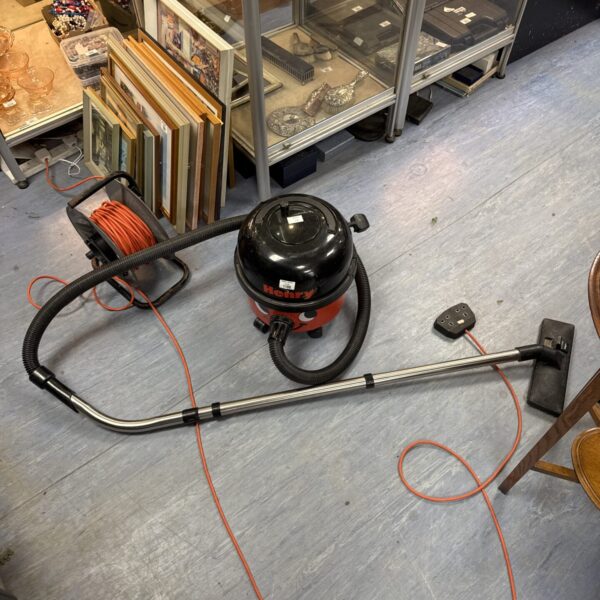 Red Numatic Henry cylinder vacuum cleaner with extension pole.