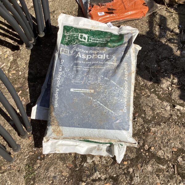 Three bags of Heidelberg Materials Drive Repair Asphalt for driveway repairs.