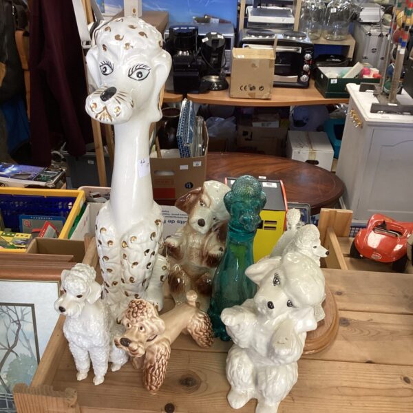 Vintage collection of white ceramic poodle figurines on display.