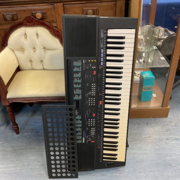 Vintage Yamaha PSR-300 keyboard with stand, a classic electronic instrument.