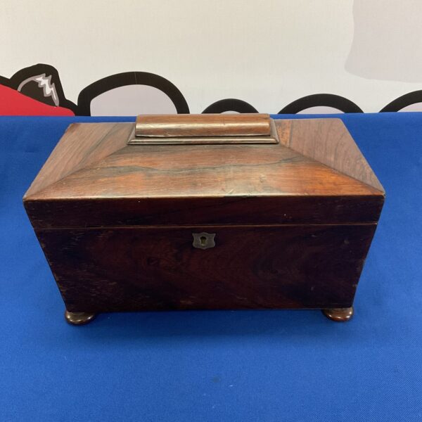 Front view of a vintage wooden sarcophagus tea caddy.