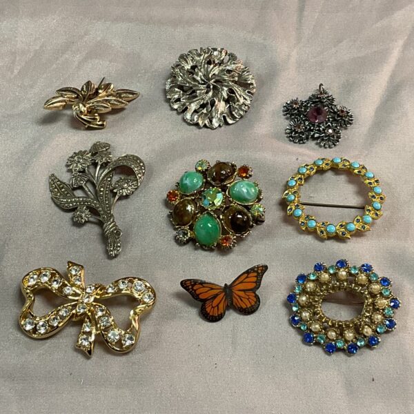 Tray of vintage costume jewellery brooches and a pendant for collectors.