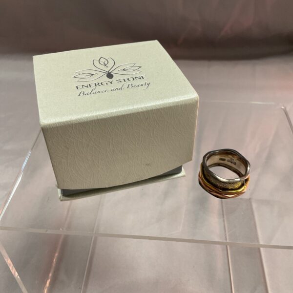Silver tone energy stone balance ring with brass and copper spinners.