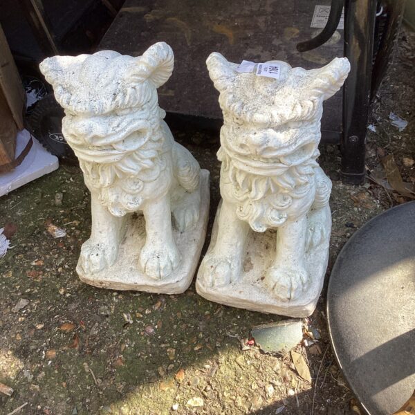 Pair of imposing dragon garden ornaments in a garden setting.