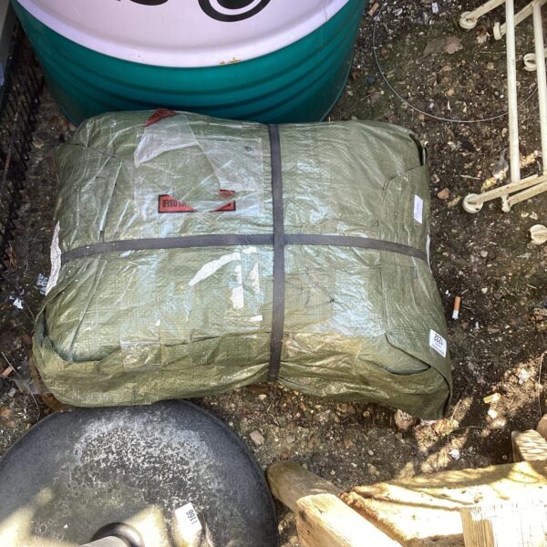 Rolled green tarpaulin for outdoor protection.