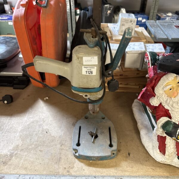 Vintage Black & Decker drill with stand on a workbench.