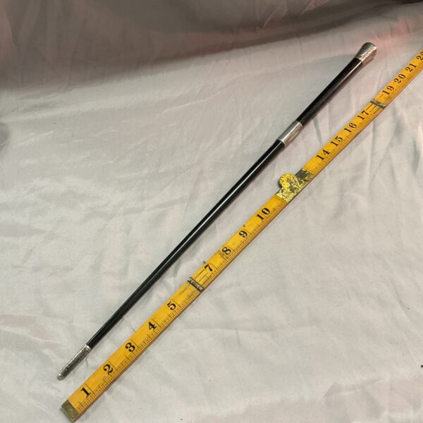 Victorian baton alongside a ruler for scale and length reference.