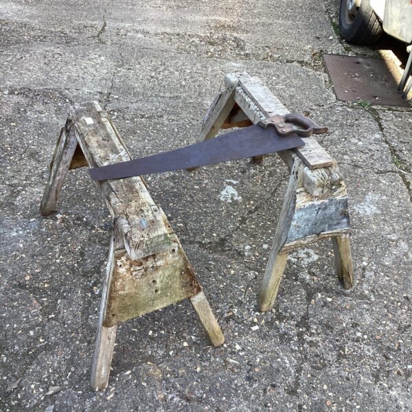 Vintage saw horses with a hand saw, rustic carpentry tools.