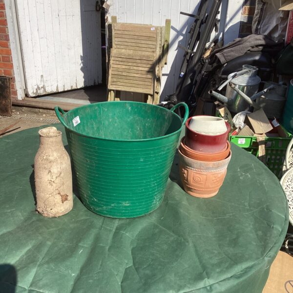 Green plastic bucket and garden planters for outdoor use.
