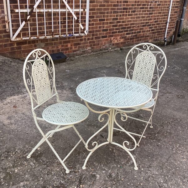 Vintage metal patio set in a garden setting.