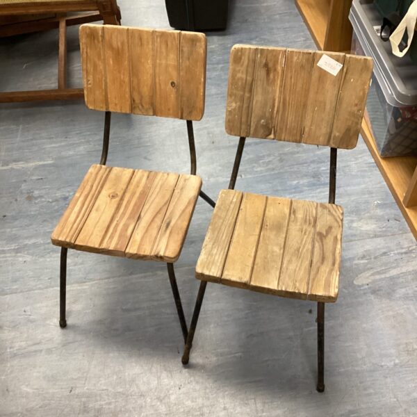 Pair of vintage wooden school chairs with metal frames.