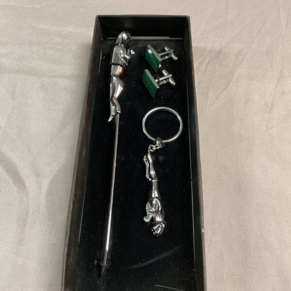Jaguar car memorabilia set featuring keyring, letter opener, and cufflinks.