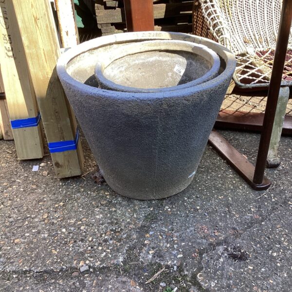 Three large terracotta garden planters with a weathered patina.