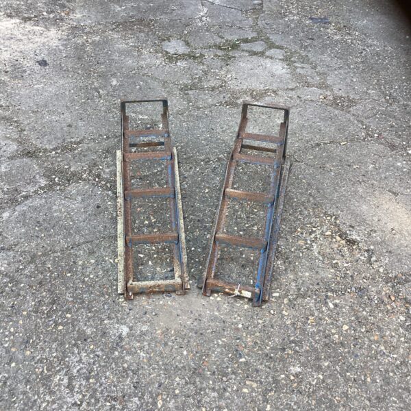 Pair of used steel car ramps for vehicle maintenance.