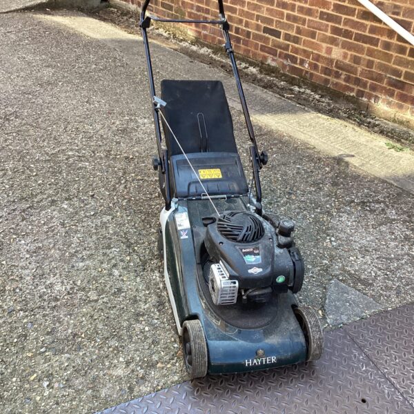 Front view of a vintage Hayter petrol lawn mower in a garden.