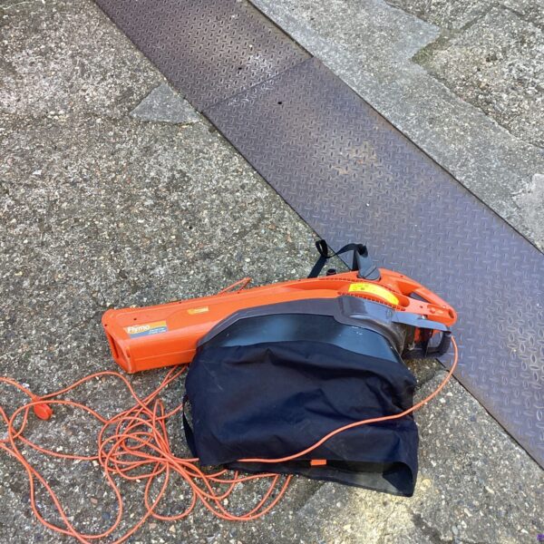 Side view of a used Flymo Garden Vac with collection bag.