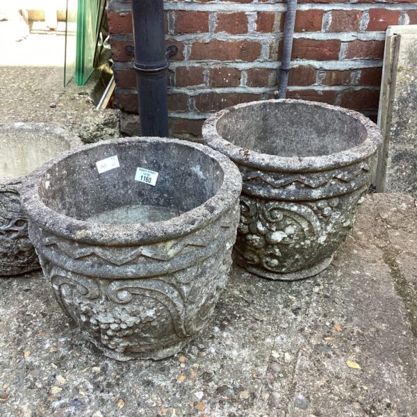 Pair of weathered stone effect garden planters for outdoor use.
