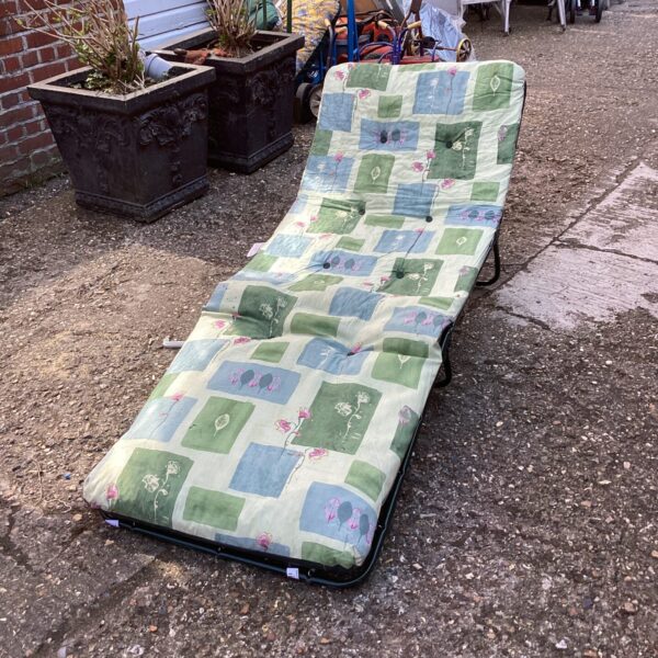 Patterned garden sun lounger for outdoor relaxation.