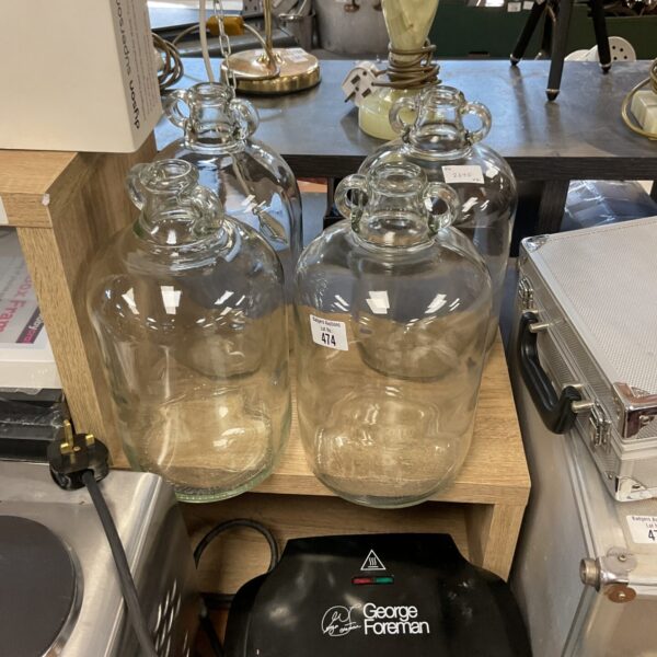 Four vintage glass demi johns for winemaking and storage.