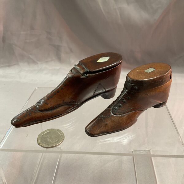 Antique Georgian shoe snuff boxes displayed on a clear base.
