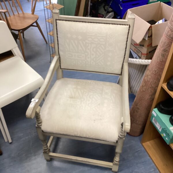 Vintage upholstered armchair with neutral toned fabric.