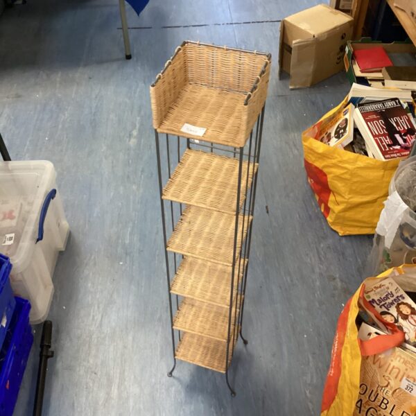 Vintage wicker bathroom shelving unit with four tiers.