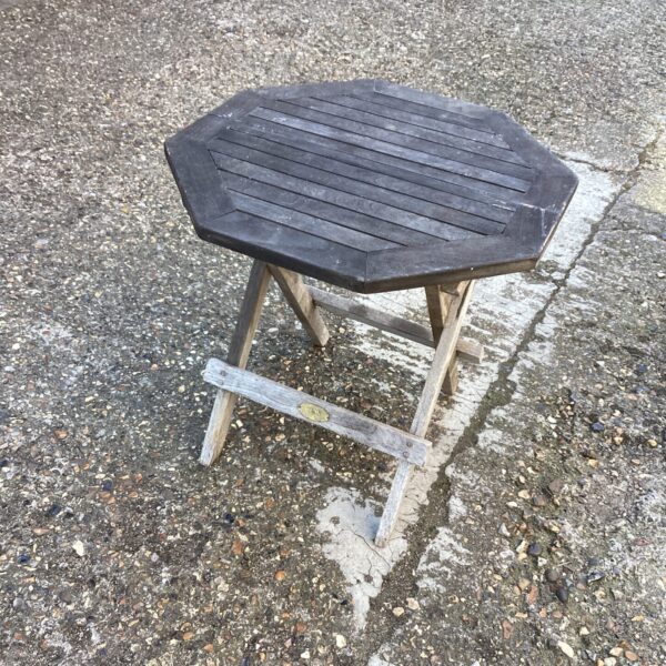 Small teak garden table with hexagonal top and folding legs.
