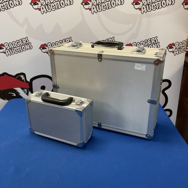 Two silver aluminium storage crates, one large and one small.