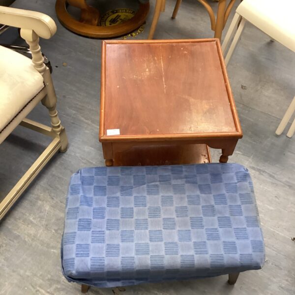 Vintage footstool with patterned upholstery and caster wheels.