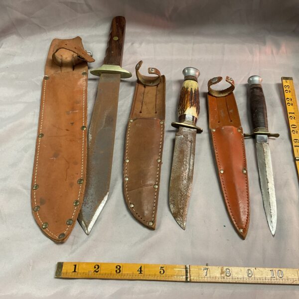 Vintage sheath knife lot with wooden handles and leather sheaths.