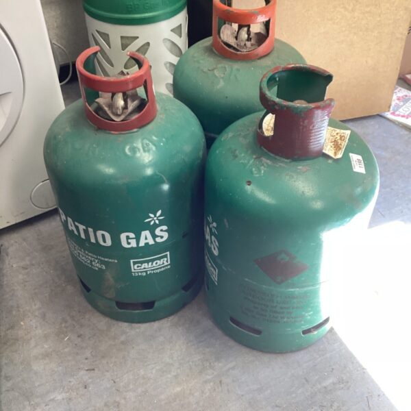 Three green butane gas bottles for camping and outdoor use.