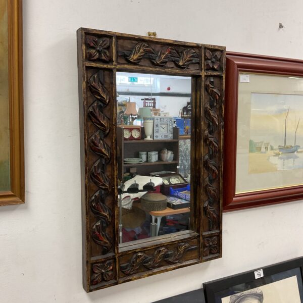 Antique carved oak mirror with detailed floral design.
