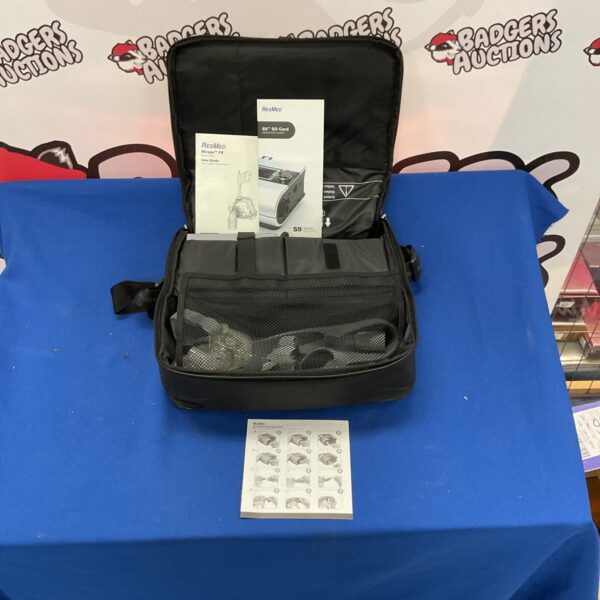 ResMed sleep apnea machine with included manuals for therapy.