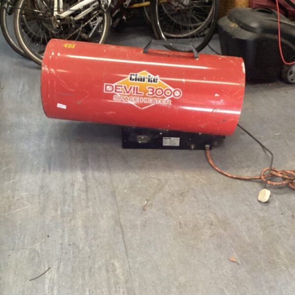 Red Clarke Devil 3000 space heater in a workshop setting.