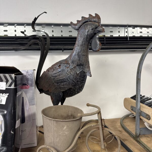 Vintage metal tricycle planter with cock ornament for garden decor.