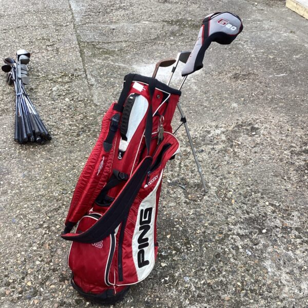 Red and black Ping G20 golf bag with clubs visible.